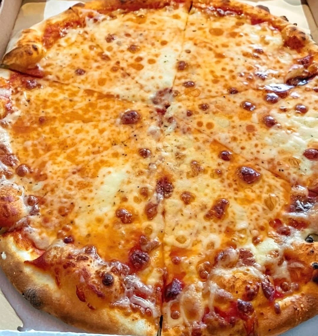 A whole cheese pizza with melted, bubbly cheese and golden-brown crust, cut into slices.