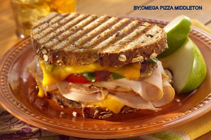 Grilled turkey and cheese panini on seeded bread served with fresh green apple slices.